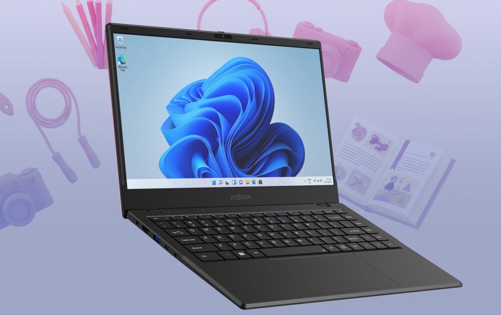 Na obrazie widoczny jest otwarty laptop z logo \'mBook\' na obudowie, wyświetlający ekran startowy systemu Windows 11. W tle znajdują się rozmyte elementy, takie jak aparat, książka i słuchawki.