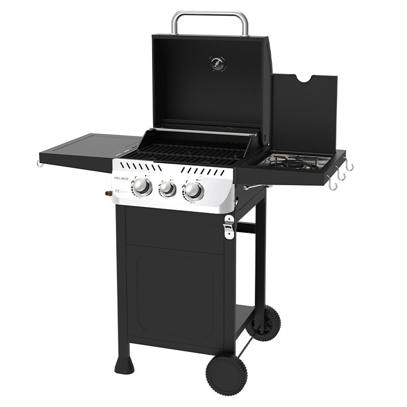 Czarny grill gazowy z trzema pokrętłami na panelu przednim, otwartą pokrywą i bocznym palnikiem. Na panelu widoczne jest logo \'VELACO\'.