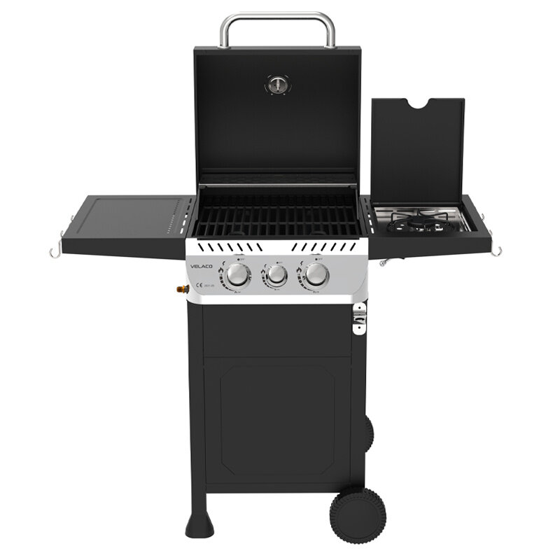 Czarny grill gazowy z trzema pokrętłami na panelu przednim i dwoma bocznymi półkami. Na pokrywie widoczne jest logo \'VELACO\'.