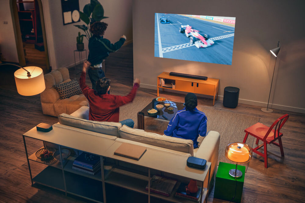 Soundbar JBL BAR 800 MkII SmartDetails subtelne efekty dźwiękowe realizm, osoby siedzące na kanapie oglądające wyscigi formuły 1