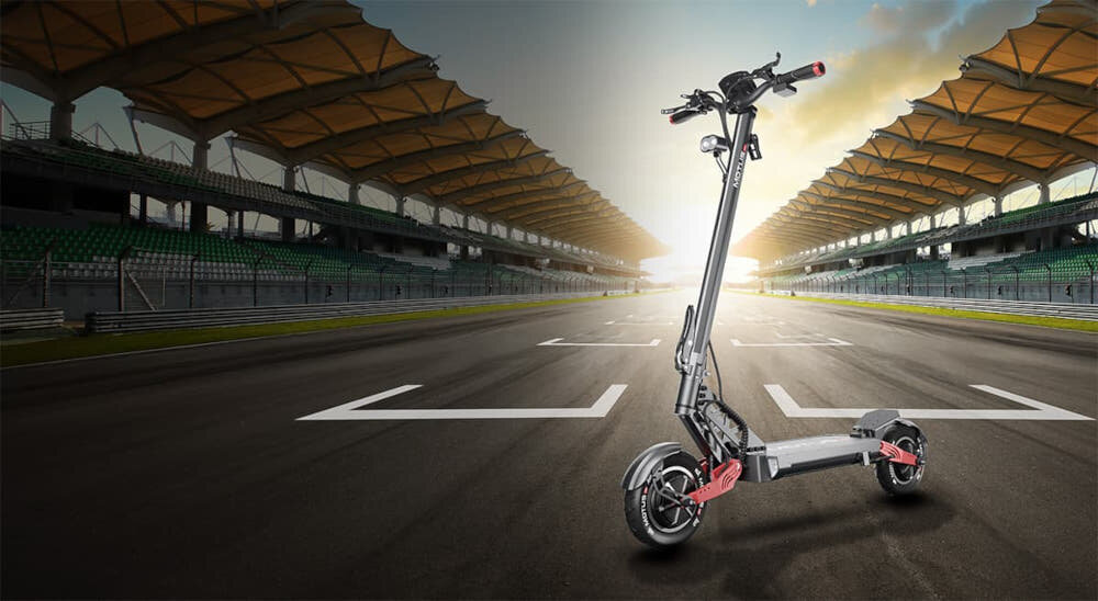 Hulajnoga elektryczna MOTUS Pro 10 Daytona 65km 2x1000W Amortyzacja 10 cali Czarny hulajnoga na tle tory wyścigowego trybuny słońće chmury do jazdy po mieście styl stabilność komfort