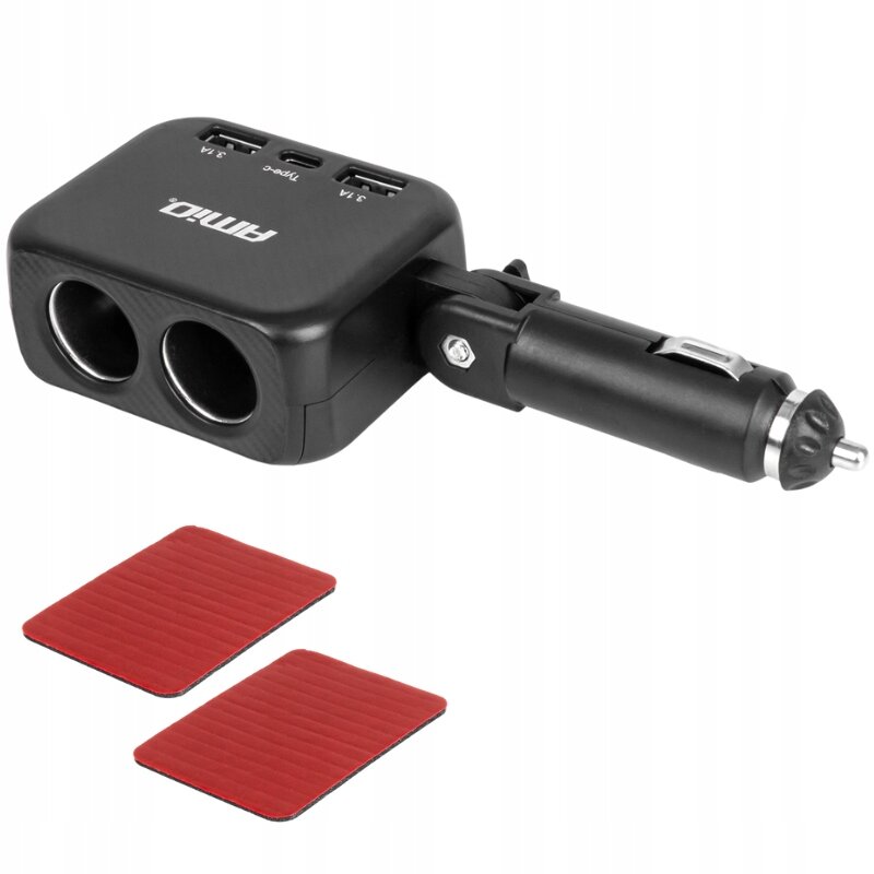 Na obrazie widoczny jest czarny rozdzielacz gniazda zapalniczki z dwoma portami USB i jednym USB-C, z logo \'AMiO\'. Obok znajdują się dwie czerwone, prostokątne podkładki.