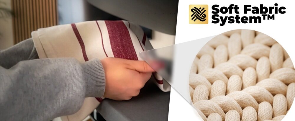 Osoba trzyma materiał w paski, a obok widoczny jest napis \'Soft Fabric System™\' oraz zbliżenie na teksturę tkaniny.
