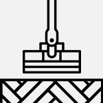 Ikona przedstawia dźwig podnoszący skrzynię nad powierzchnią z desek, w czarno-białej kolorystyce.