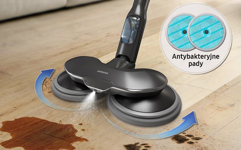 Odkurzacz z logo Samsung spryskuje podłogę, usuwając zabrudzenia. Obok widoczna jest grafika z napisem \'Antybakteryjne pady\'.