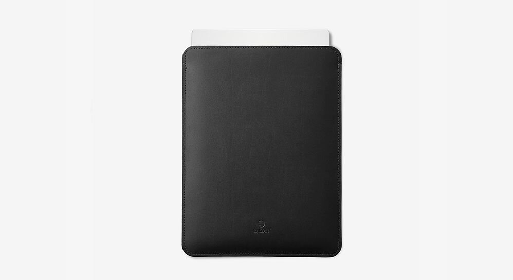 Czarne etui na laptopa z widocznym logo producenta na dole. W etui znajduje się biały element wystający z góry.