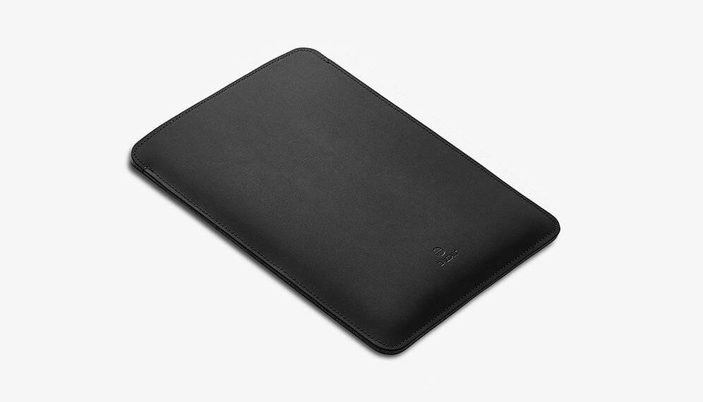 Czarne etui na laptopa o prostokątnym kształcie, z widocznym logo producenta na powierzchni. Etui ma gładką teksturę i zaokrąglone rogi.