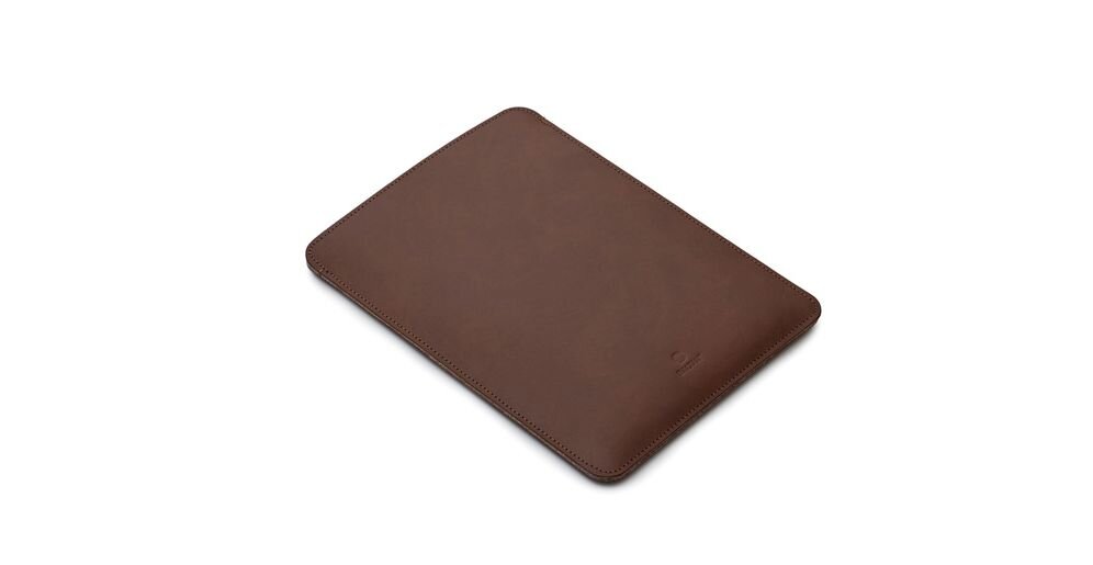 Ciemnobrązowe etui na laptopa o prostokątnym kształcie, wykonane z gładkiego materiału. Na powierzchni widoczne jest subtelne logo producenta.