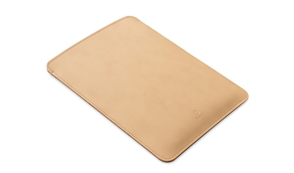 Beżowe etui na laptopa o prostokątnym kształcie z widocznym logo producenta w dolnej części.