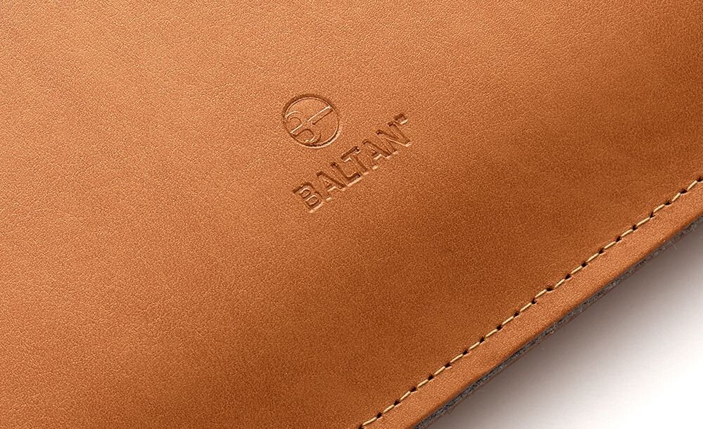 Jasnobrązowe etui z widocznym logo \'BALTAN\' wytłoczonym na powierzchni. Widoczny jest również delikatny szew wzdłuż krawędzi.