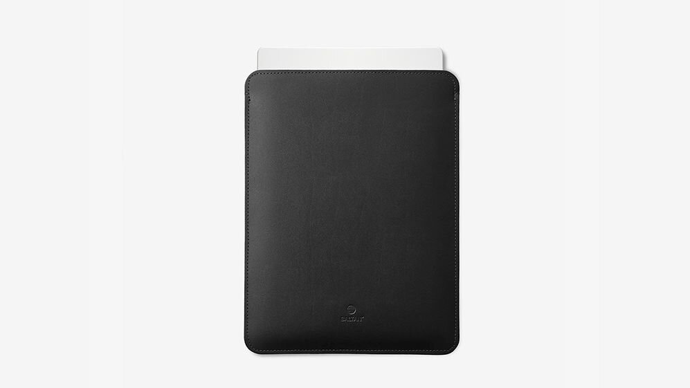 Czarne etui na laptopa z widocznym logo producenta na dole. W etui znajduje się biały przedmiot, prawdopodobnie laptop.