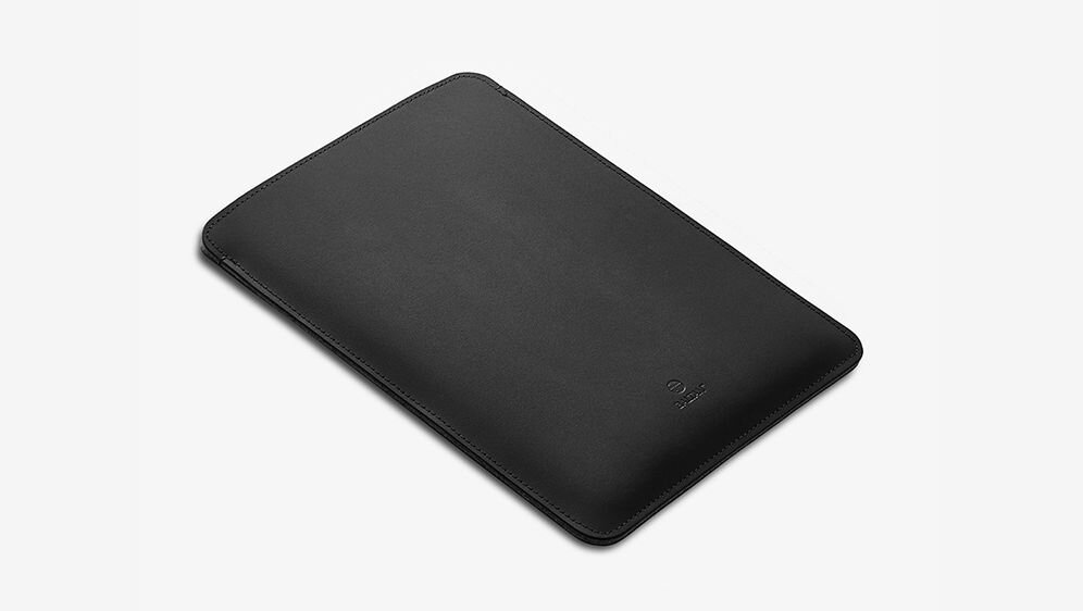Czarne etui na laptopa o prostokątnym kształcie z delikatnym logo na powierzchni.