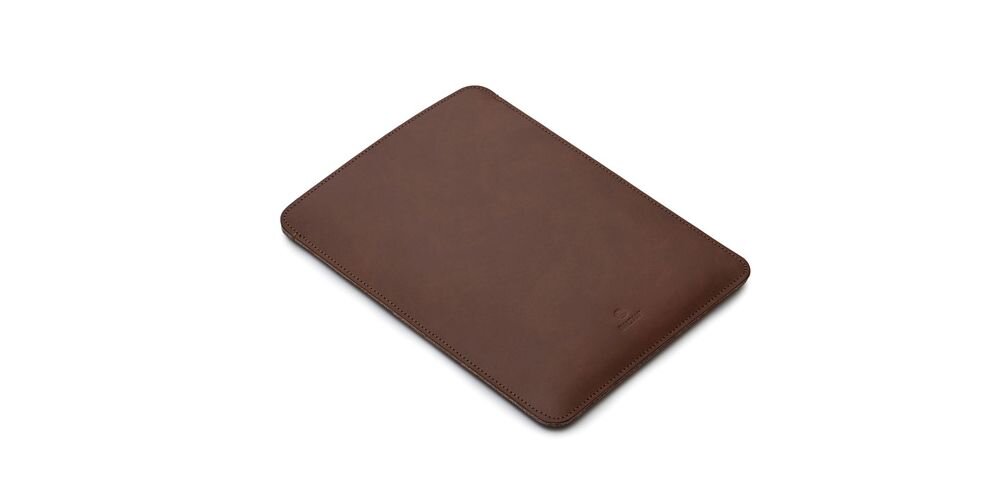 Ciemnobrązowe etui na laptopa o prostokątnym kształcie, wykonane z gładkiego materiału. Na powierzchni widoczne jest subtelne logo producenta.