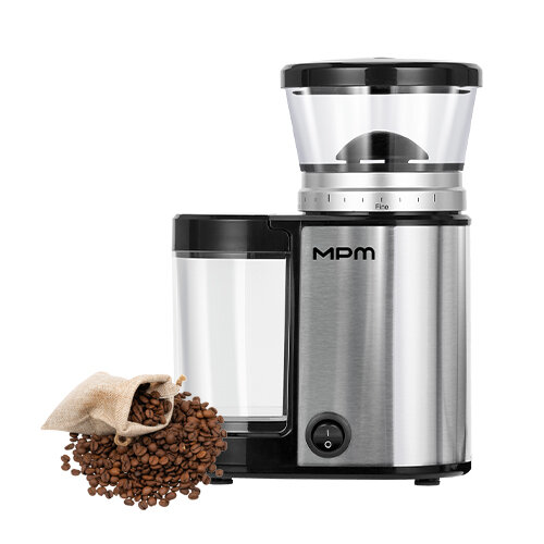 Na obrazie widoczny jest młynek do kawy z metaliczną obudową i przezroczystym pojemnikiem na ziarna. Obok młynka znajduje się worek z rozsypanymi ziarnami kawy, a na urządzeniu widnieje logo \'MPM\'.