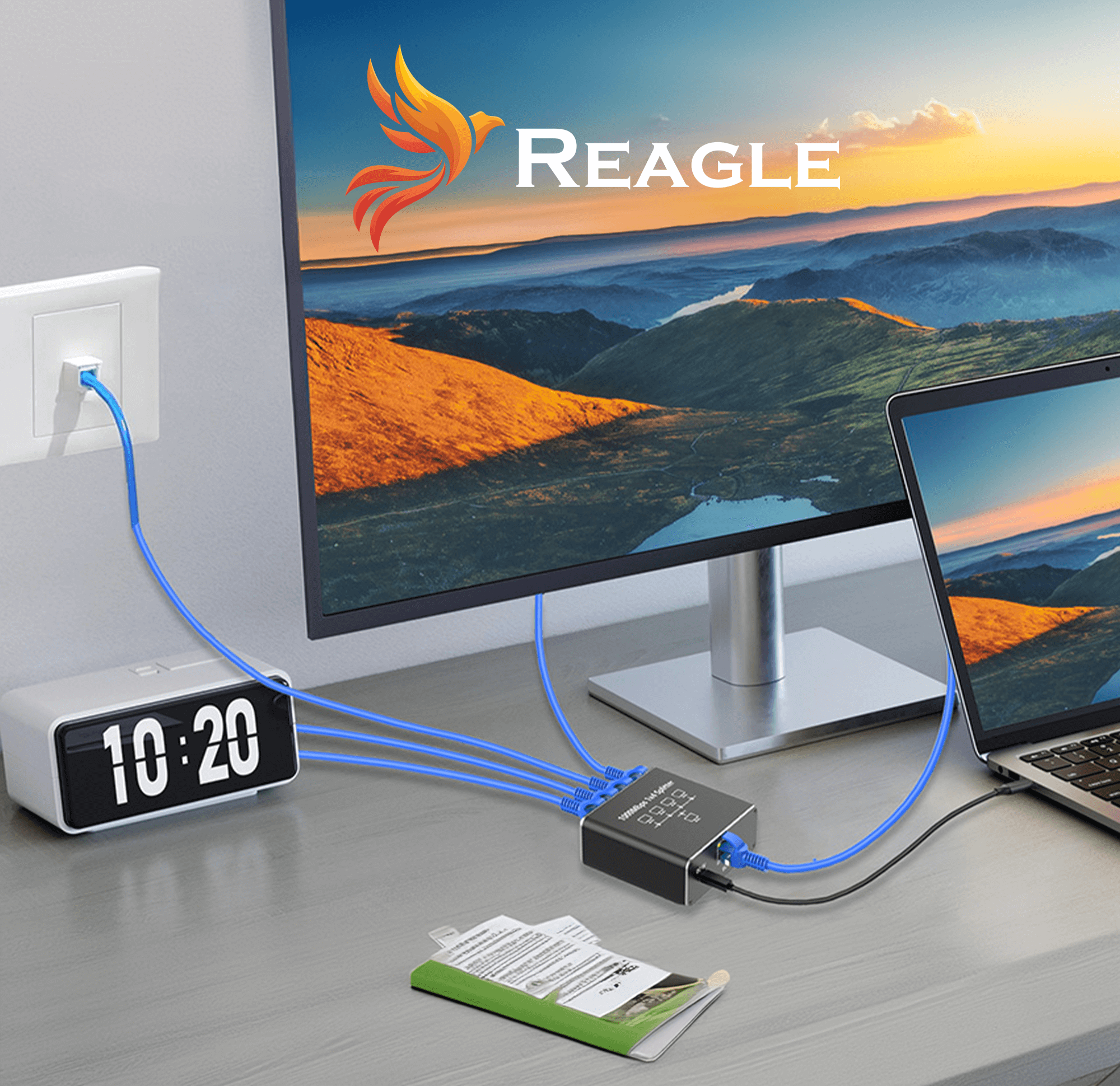 Na biurku znajduje się adapter sieciowy z napisem \'REAGLE RSPLI7\', do którego podłączone są niebieskie kable Ethernet. W tle widać monitor z krajobrazem górskim i logo \'Reagle\'.