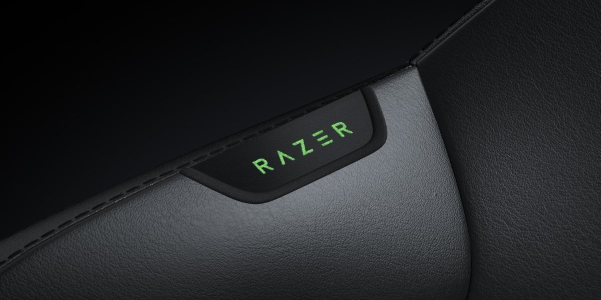 Przybliżenie na element krzesła Razer Iskur V2 Newgen, widoczne jest naszyte logo 'RAZER'.