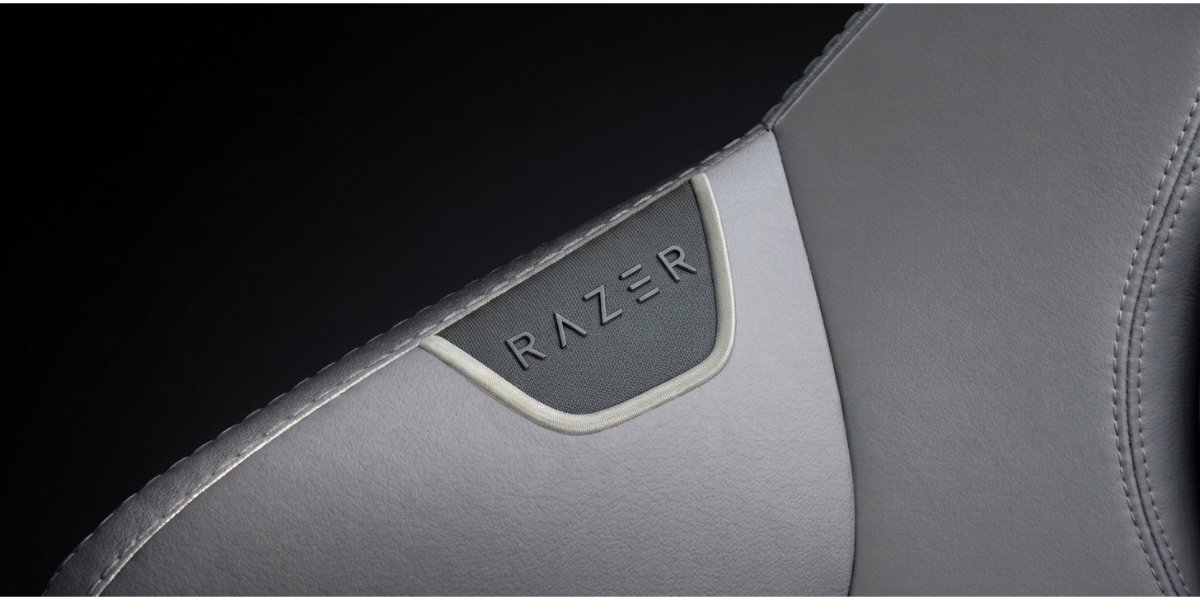 Przybliżenie na element krzesła Razer Iskur V2 Newgen, widoczne jest naszyte logo 'RAZER'.