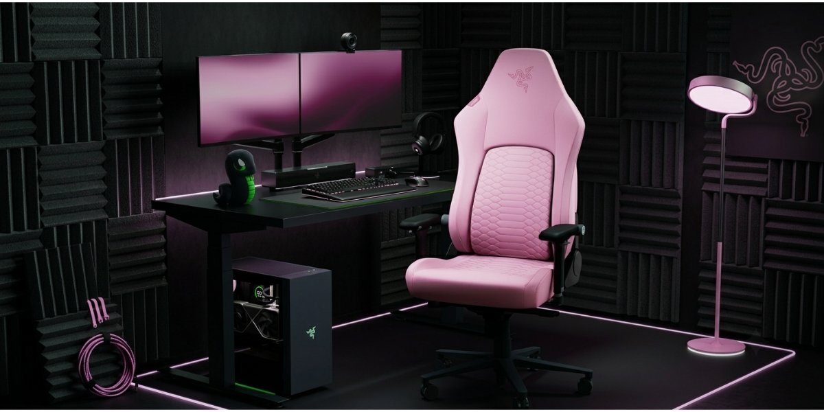 Fotel gamingowy Razer Iskur V2 Newgen przy stacji gamingowej na tle pokoju obłożonego pianką akustyczną.