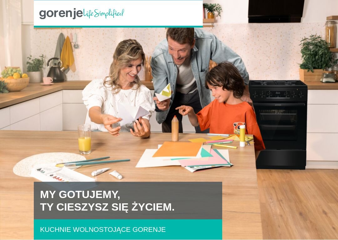 KUCHNIA GORENJE MEKS5141BM Rodzina złożona z dwóch dorosłych i dziecka spędza czas przy kuchennym stole, wycinając kolorowe elementy z papieru, w tle widoczna jest zabudowa kuchenna z kuchnią wolnostojącą Gorenje, a u dołu znajduje się napis „MY GOTUJEMY, TY CIESZYSZ SIĘ ŻYCIEM. KUCHNIE WOLNOSTOJĄCE GORENJE”