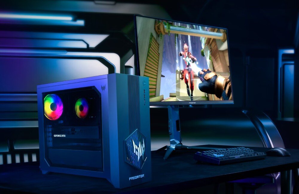Komputer ACER Predator Orion PO3-665 Komputer stacjonarny z przezroczystym panelem bocznym stojący na biurku obok monitora z włączoną grą, klawiatury oraz myszy