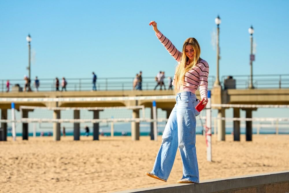 JBL Go 5 odporność IP68 wodoodporny pyłoszczelny wytrzymała konstrukcja outdoor, osoba stojąca na murku trzymająca głośnik mobilny