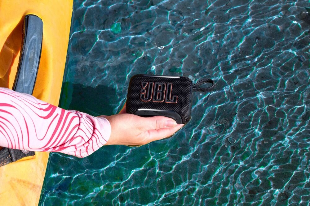 JBL Go 5 Bluetooth 6.0 kodeki SBC AAC LC3 stabilne połączenie bezprzewodowe audio, osoba siedząca w kajaku trzymająca głośnik mobilny