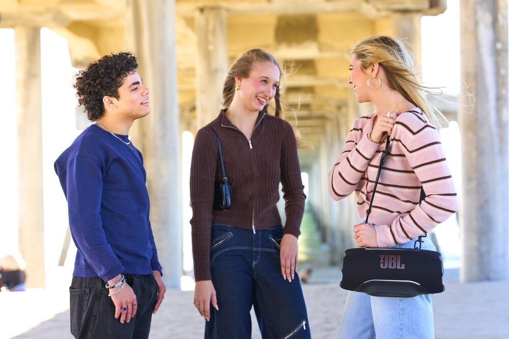 Głośnik mobilny JBL Xtreme 5 Smart EQ automatyczna regulacja dźwięku podcast muzyka, osoba z zawieszonym głośnikiem mobilnym na ramienu