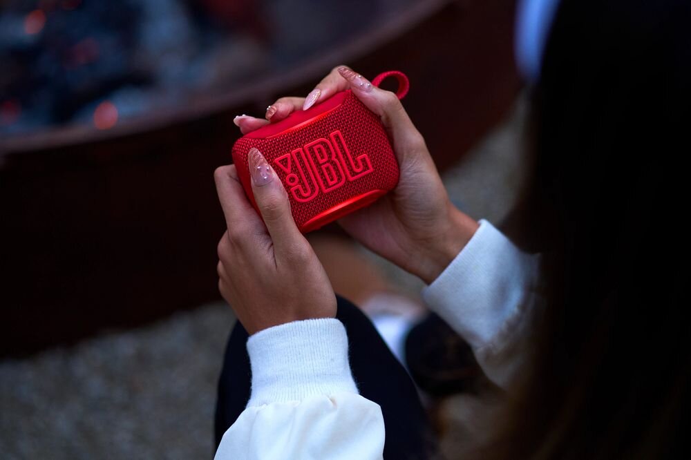 JBL Go 5 czas pracy 10 godzin Playtime Boost akumulator 3.85Wh ładowanie USB-C, osoba trzymająca głośnik mobilny w rękach