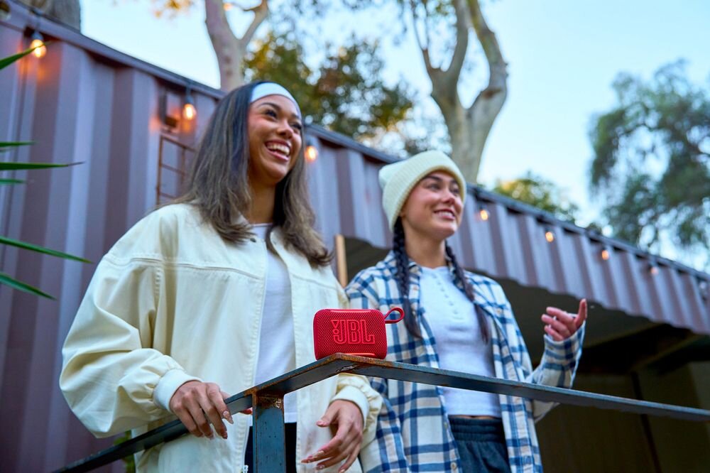 JBL Go 5 AirTouch stereo Auracast łączenie głośników bezprzewodowe nagłośnienie, osoby stojące przy barierce, głośnik mobilny stojący na barierce