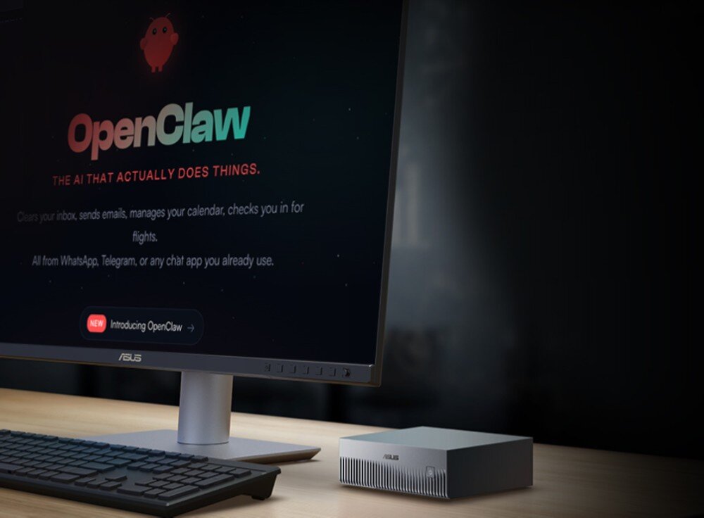 Na biurku znajduje się monitor z widocznym tekstem: \'OpenClaw The AI that actually does things.\' oraz komputer ASUS w formie małej, srebrnej skrzynki z logo ASUS.