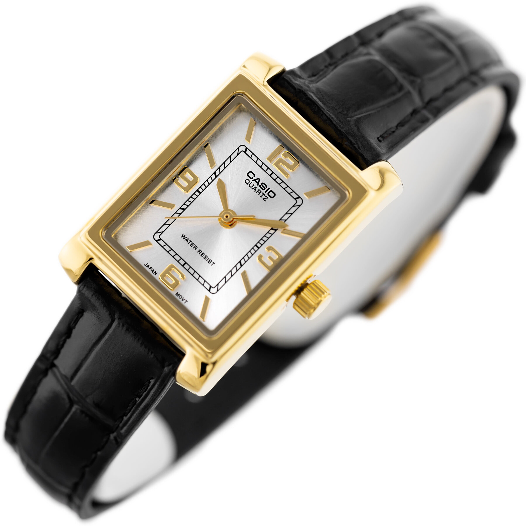 Zegarek z prostokątną, złotą kopertą i białą tarczą z oznaczeniami godzinowymi oraz napisem \'CASIO QUARTZ\' i \'WATER RESIST\'. Pasek jest czarny, wykonany z materiału imitującego skórę.
