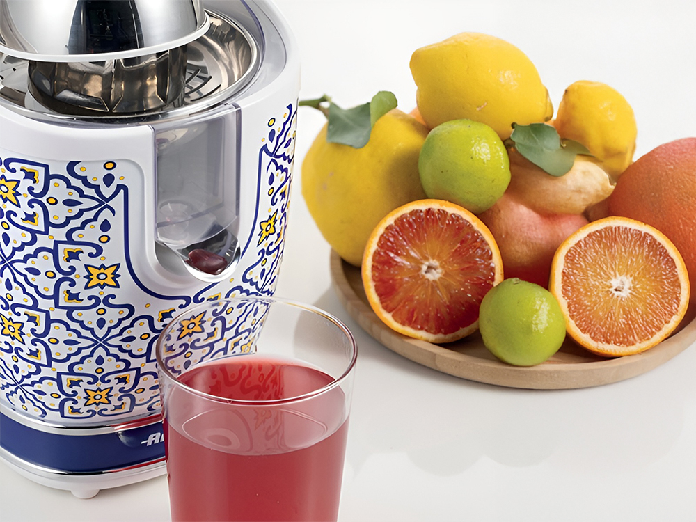 Wyciskarka do cytrusów ARIETE Capri 413 jasne tło wyciskarka biało niebieska kolorystyka obudowy żółte elementy metalowe elementy czerwony sok w szklance styl funkcjonalność Sitko ze stali nierdzewnej aksamitnie gładka konsystencja  Solidna konstrukcja trwałość świeży smak owoców w każdej kropli soku optymalny smak wygoda w eleganckim wydaniu  