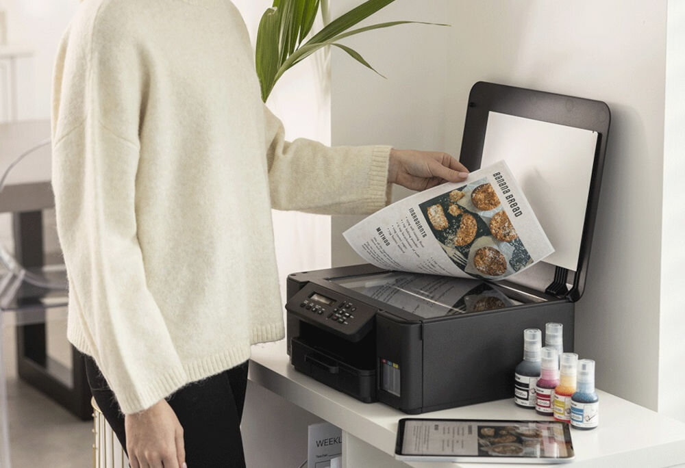 Urządzenie wielofunkcyjne BROTHER DCP-T535DW Druk w kolorze, Automatyczny druk dwustronny, Wi-Fi kobieta stojąca przy urządzeniu i wkładająca kartkę do skanera w pomieszczeniu rozdzielczość skanowania w kolorze dokumenty zdjęcia rozdzielczość interpolowana wysoka jakość