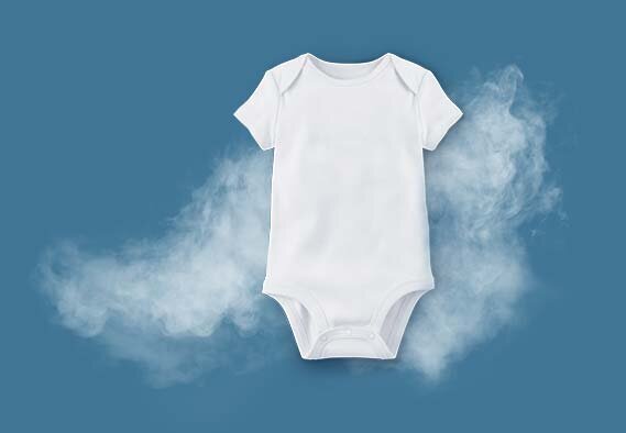 Na niebieskim tle znajduje się białe body dziecięce, wokół którego unosi się delikatna mgiełka.