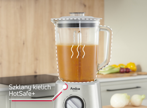 Na obrazie znajduje się blender kielichowy z logo Amica, wypełniony pomarańczowym płynem. Obok widoczny jest tekst: \'Szklany kielich HotSafe+\'.