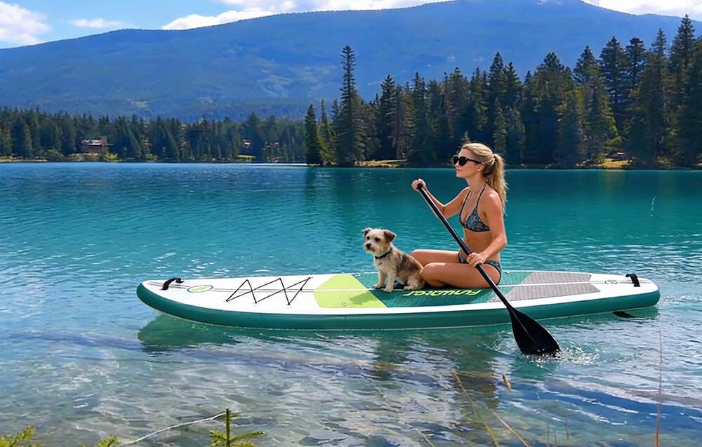 Deska SUP FUNWATER SUPFW69A Zielono-biały, uniwersalna, deska, rekreacja, jezioro, Kobieta ćwiczy na desce SUP na spokojnej wodzie.