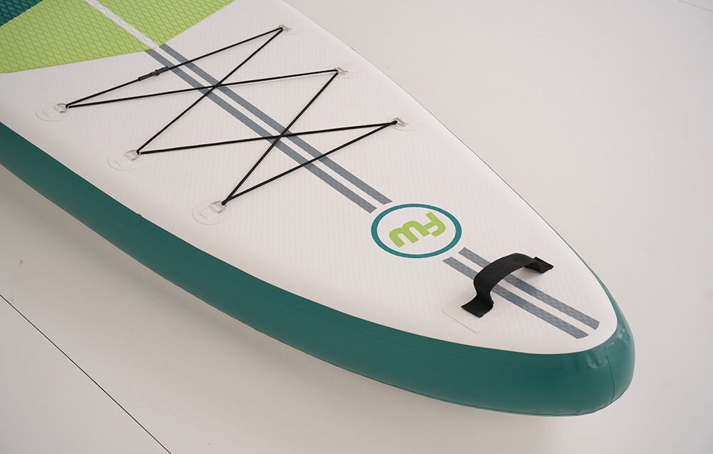 Deska SUP FUNWATER SUPFW69A Zielono-biały, pianka, EVA, przyczepność, joga, Kobieta niesie deskę SUP po piaszczystej plaży.