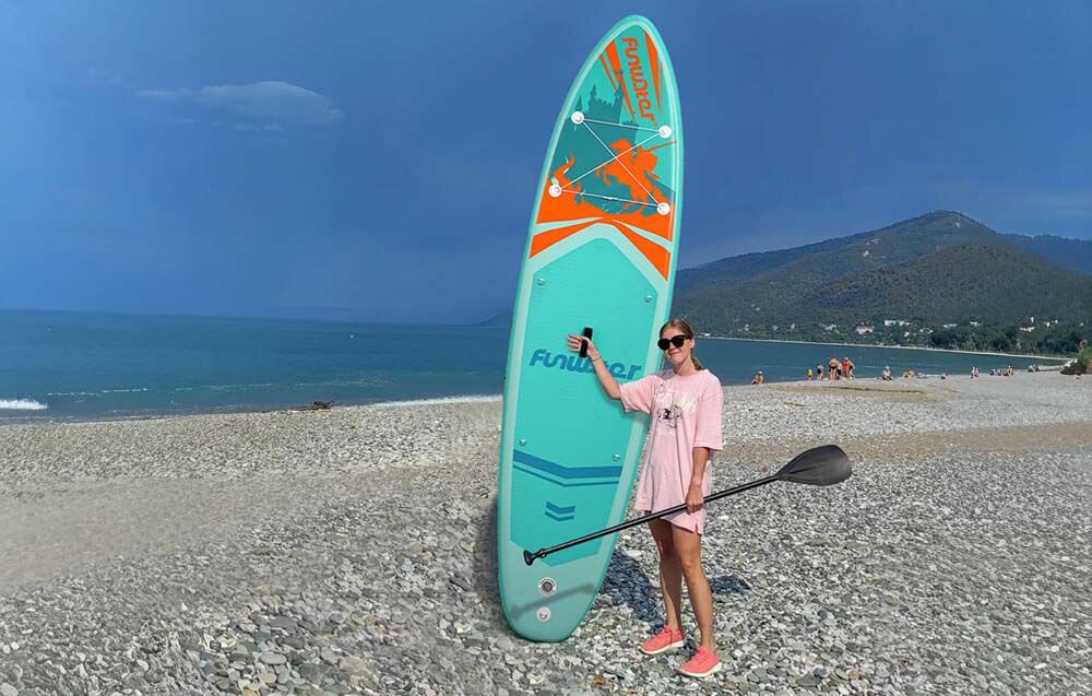 Deska SUP FUNWATER SUPFW70A Turkusowy, uniwersalna, deska, rekreacja, jezioro, Kobieta ćwiczy na desce SUP na spokojnej wodzie.