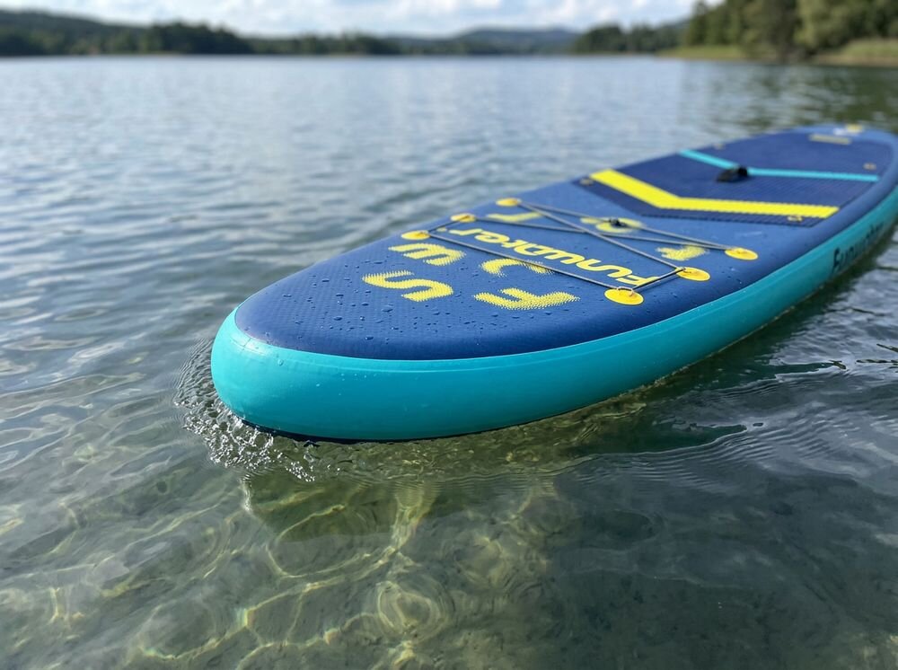 Deska SUP FUNWATER SUPFW71A Granatowy, uniwersalna, deska, rekreacja, jezioro, Kobieta ćwiczy na desce SUP na spokojnej wodzie.