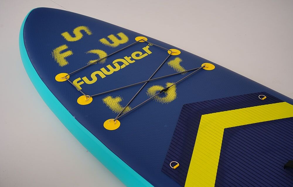 Deska SUP FUNWATER SUPFW71A Granatowy, pianka, EVA, przyczepność, joga, Kobieta niesie deskę SUP po piaszczystej plaży.