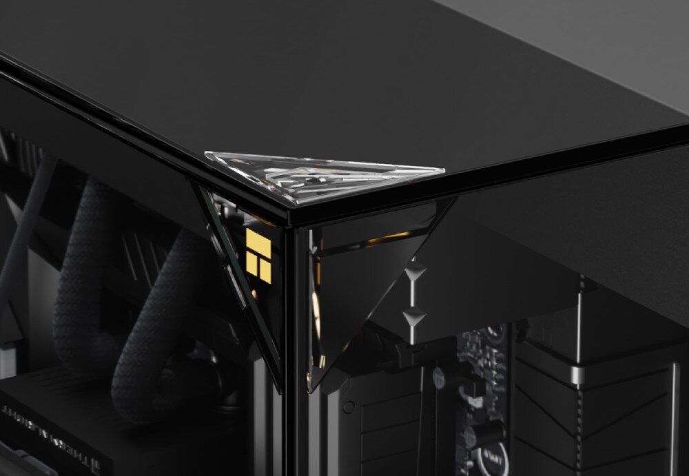 Obudowa THERMALRIGHT A70 Fan zbliżenie na górny narożnik czarnej obudowy komputerowej w miejscu łączenia się szklanych paneli, pod którymi znajduje się małe złote logo producenta