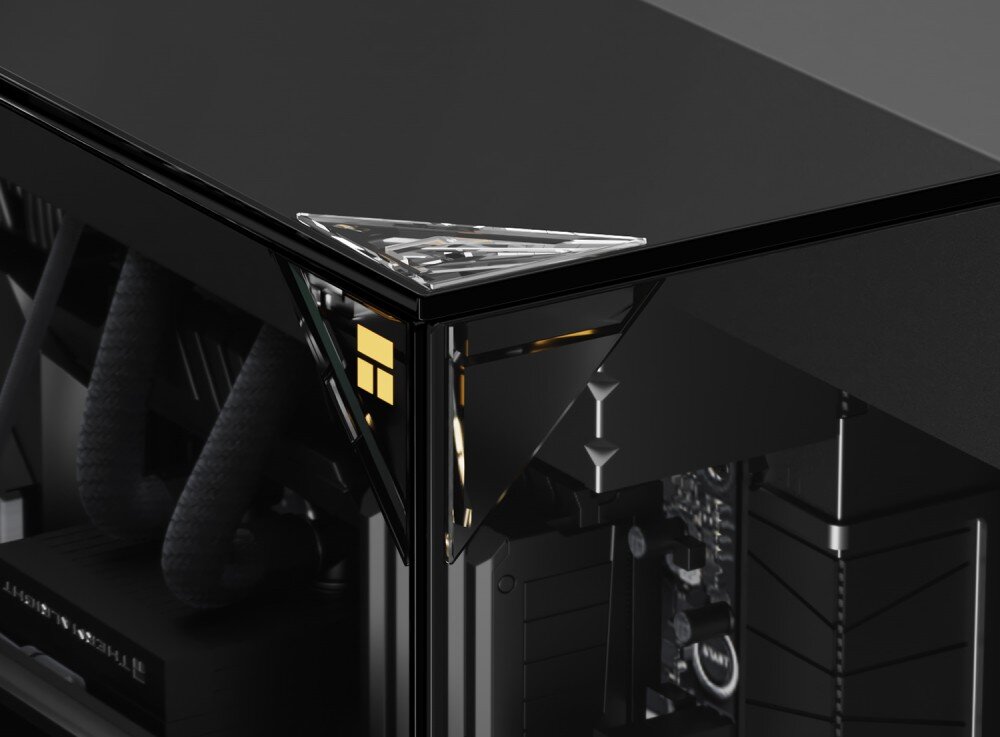 Obudowa THERMALRIGHT A70 ARGB Fan Zbliżenie na górny narożnik obudowy pokazujące bezsłupkowe łączenie szklanych paneli, na rogu znajduje się trójkątny element wykończeniowy ze złotym logo, a w głębi widać fragmenty wewnętrznych komponentów i rurki chłodzenia wodnego