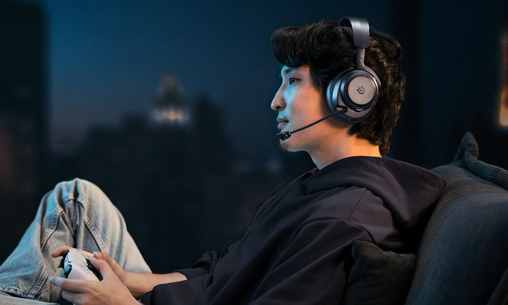 STEELSERIES Arctis Nova Pro Omni słuchawki gamingowe mikrofon ClearCast Pro szerokie pasmo komunikacja, osoba z założonymi słuchawkami