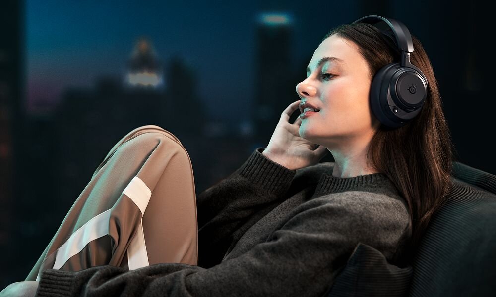 STEELSERIES Arctis Nova Pro Omni słuchawki gamingowe ANC aktywna redukcja hałasu tryb transparentny, osoba z założonymi słuchawkami