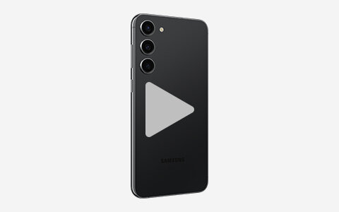 Czarny smartfon z trzema aparatami z tyłu, widoczny na białym tle. Na ekranie znajduje się szary symbol odtwarzania wideo.