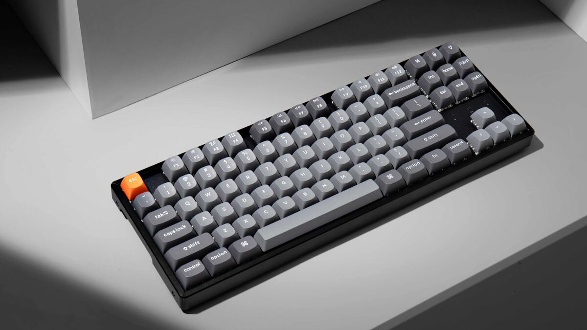 Keychron K8 Max - Klawiatura zaprezentowana pod kątem w otoczeniu minimalistycznych kształtów i cieni.