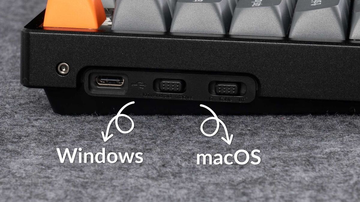 Keychron K8 Max Połączenie 2.4 GHz (odbiornik USB-A) częstotliwość raportowania do 1000 Hz Bluetooth 5.1 przewodowy USB typu C przełącznik trybu macOS/Windows - Zbliżenie na boczny profil klawiatury z przełącznikami suwakowymi, oznaczonymi napisami Windows i macOS ze strzałkami.
