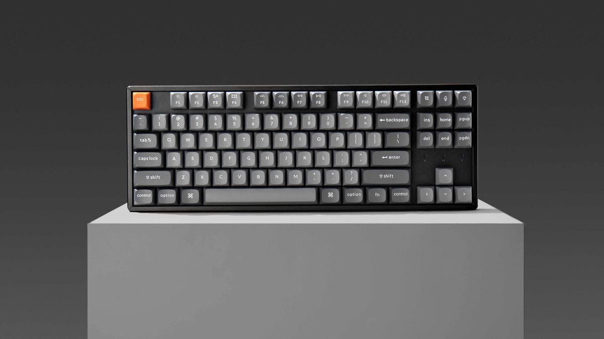 Keychron K8 Max stalowej płyty montażowej wielowarstwowym systemem pianek akustycznych IXPE, PET oraz EPDM tłumić wibracje i redukować niepożądane dźwięki Konstrukcja - Klawiatura zaprezentowana od przodu na podwyższeniu.