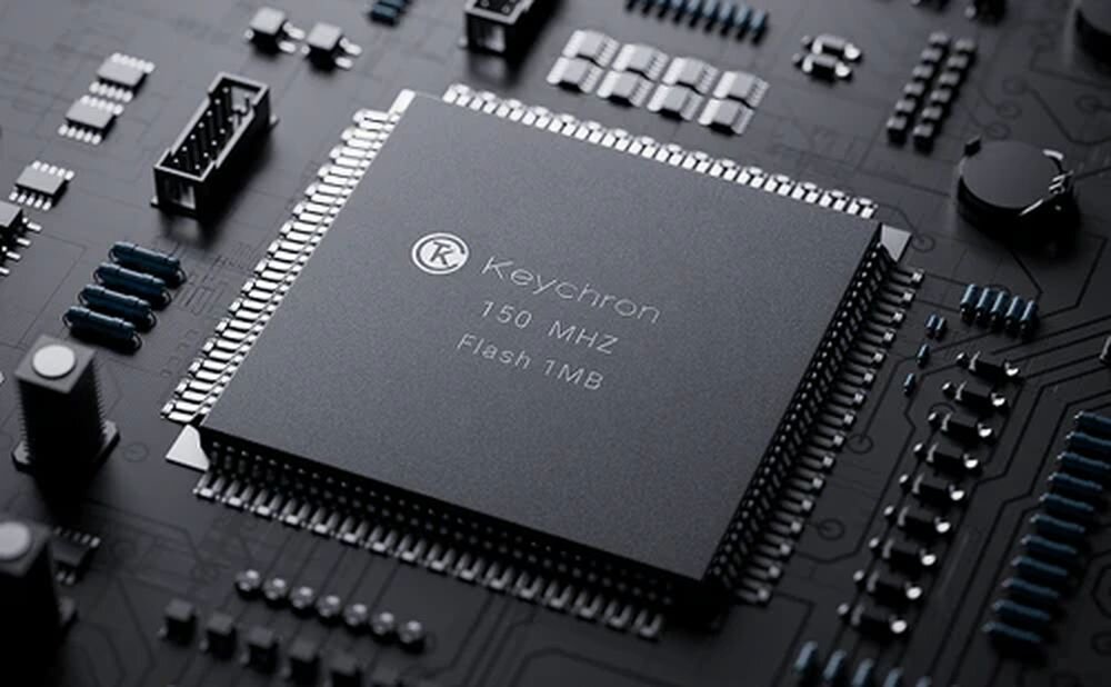 Zdjęcie przedstawia zbliżenie na układ scalony z napisem \'Keychron 150 MHZ Flash 1MB\' na tle płyty głównej z różnymi komponentami elektronicznymi.