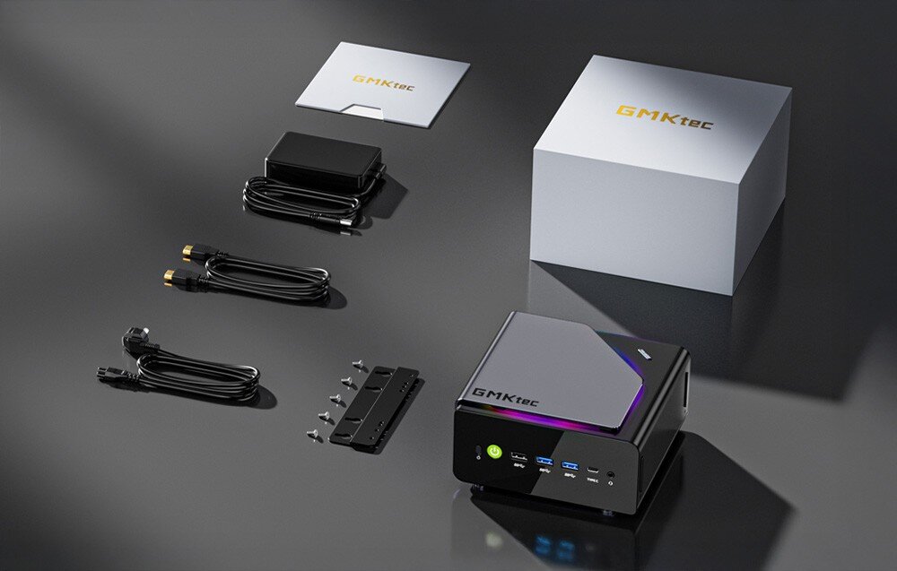 Komputer GMKTEC K15-32RAM Zdjęcie zestawu PC GMKtec K15, zasilacz, kable połączeniowe, uchwyt montażowy oraz instrukcję obsługi w białym pudełku, komplet